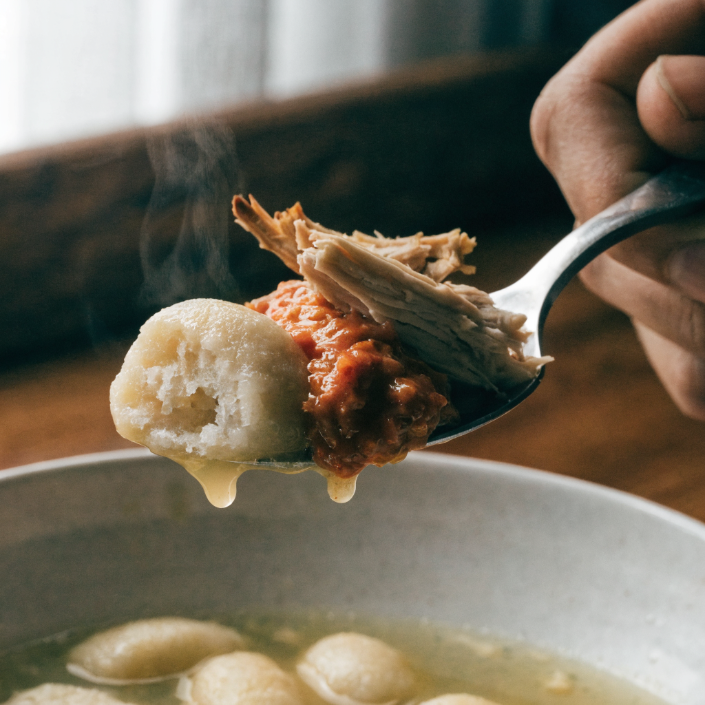 Close-up of rich, creamy chicken & gnocchi soup with sun-dried tomato sauce